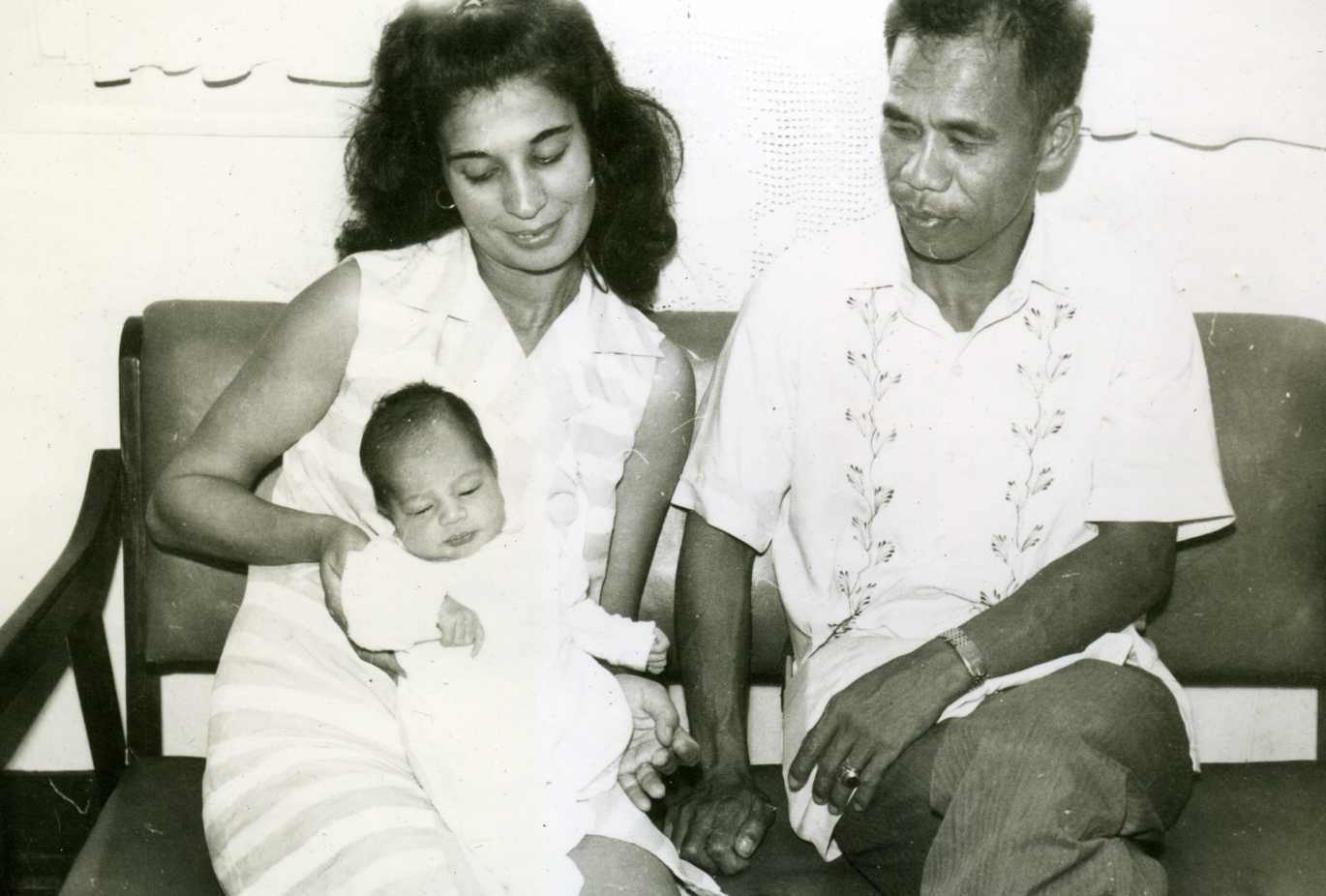 Sina Fred at Evelyn kasama ang isang bagong silang na sanggol. Sinasabi ng pahina ng album na 1969 ito at Ferdinand ang kanyang pangalan; inisip naman sa blog ni Kevin kung baka si Dolly ito, mga 1963.