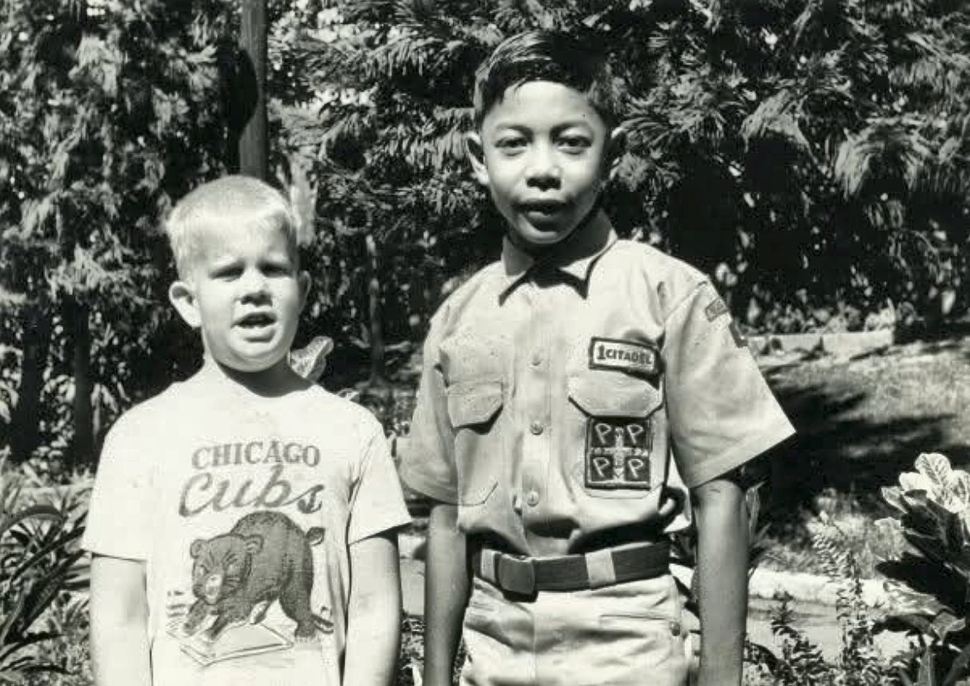 Si Kevin Engle na nakasuot ng T-shirt ng Chicago Cubs, katabi si Eddie Alfonso na nakauniporme ng Brigade, sa isang hardin